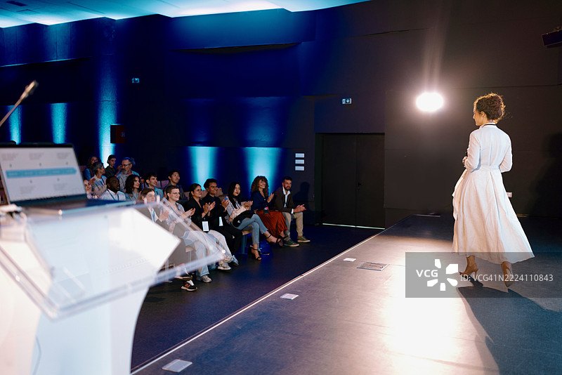 观众在商业会议上为嘉宾演讲者热烈鼓掌图片素材