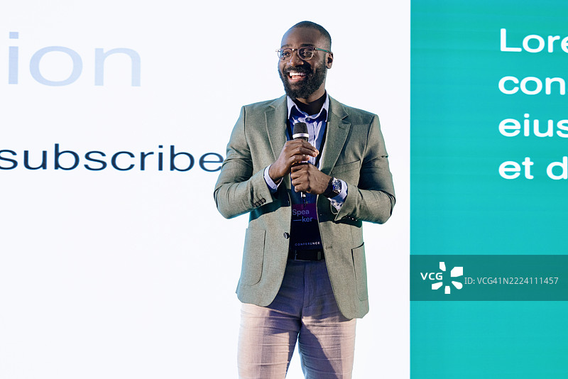 自信的演讲者在现代场馆的专业科技会议上发言图片素材