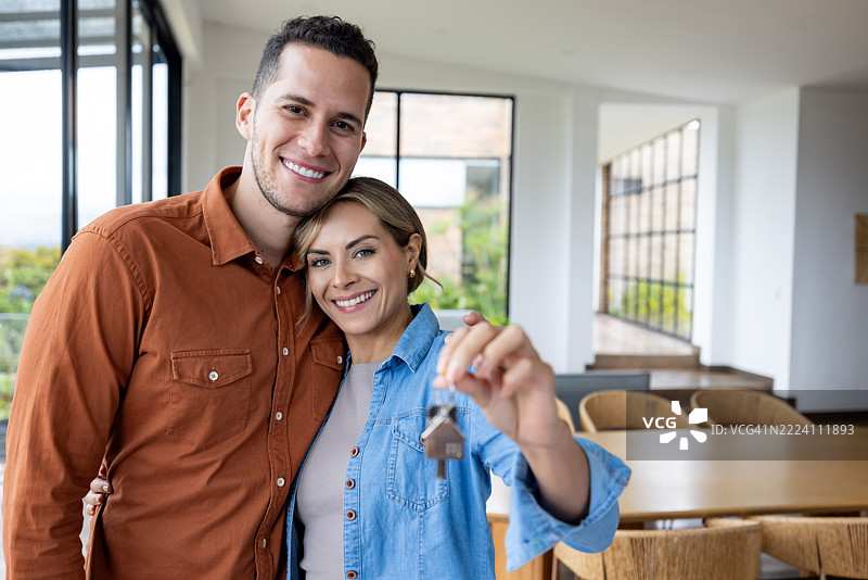 一对恩爱情侣购买房子并手握钥匙的肖像图片素材