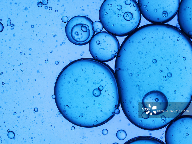 液体气泡漂浮在一杯蓝色饮料中。图片素材