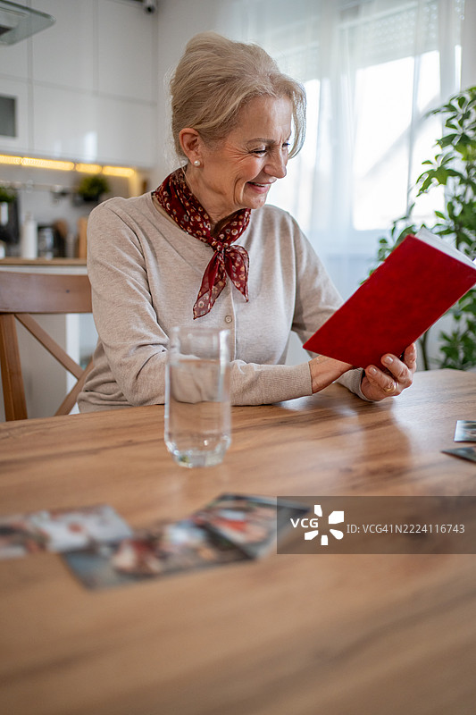 一位老年女性在欣赏照片中的回忆图片素材