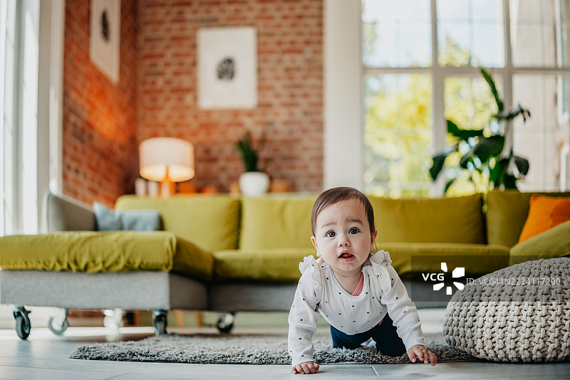 混血女孩在明亮的公寓里爬行图片素材