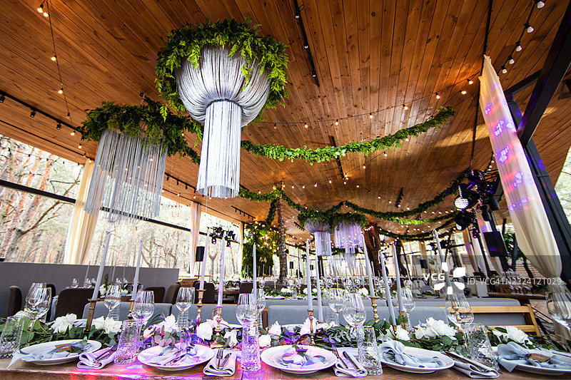 优雅的活动布置，展现精致的装饰和现代场地中的桌子摆设，四周环绕着自然景观。图片素材