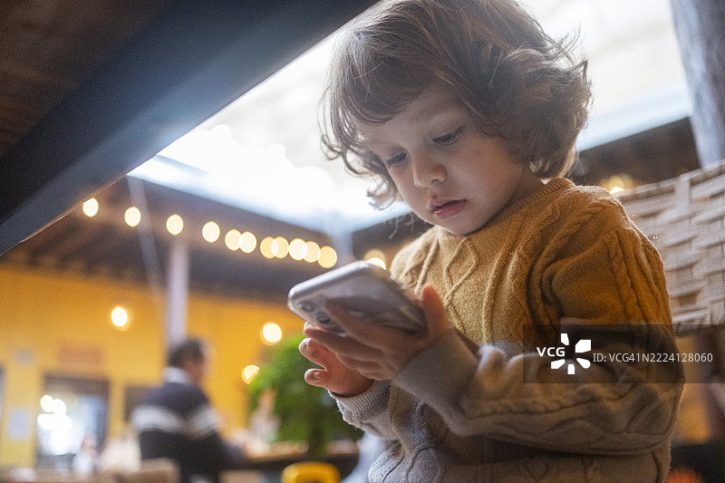 金发男孩在玩手机图片素材