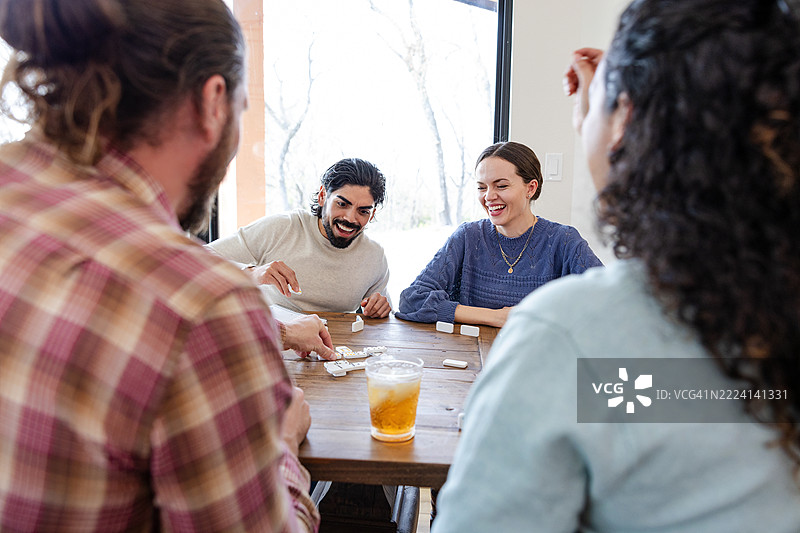 多种族朋友在室内一起玩多米诺骨牌图片素材