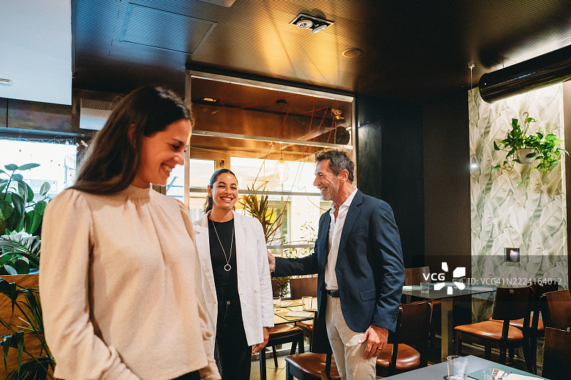 餐厅经理在入口处欢迎顾客图片素材