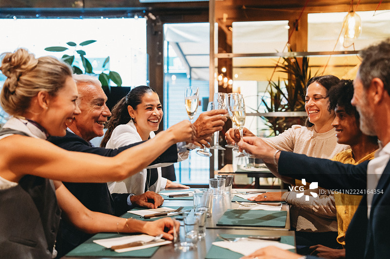 愉快的商务团队在餐厅举杯庆祝成功图片素材