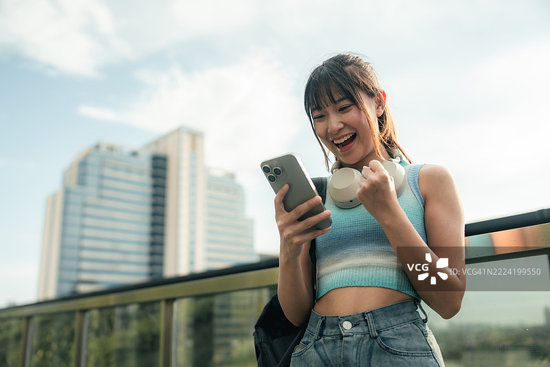 Gen Z woman looks at stock chart in smartphone图片素材