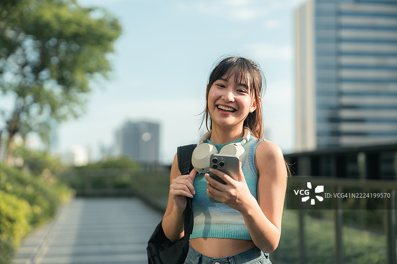 Gen Z woman looks at stock chart in smartphone图片素材