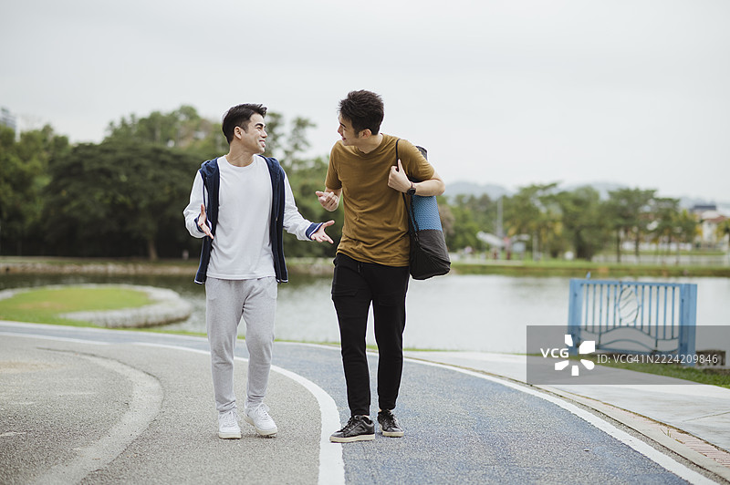 两位亚洲运动员在锻炼后分享经验。图片素材