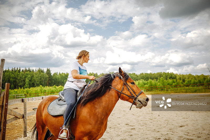 金发女性在夏日享受骑马乐趣图片素材