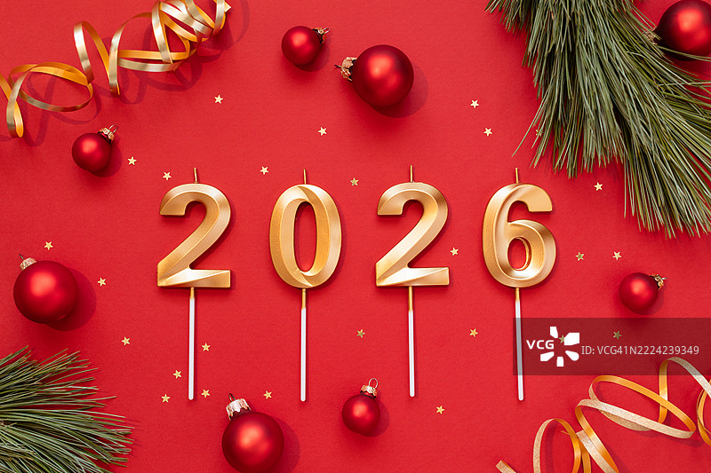 2026年金色数字的圣诞组合，红色球饰、金色星星和松枝，红色背景，俯视图图片素材