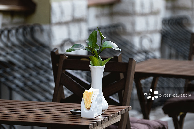 户外咖啡馆，木桌、花瓶和餐巾纸架的特写图片素材