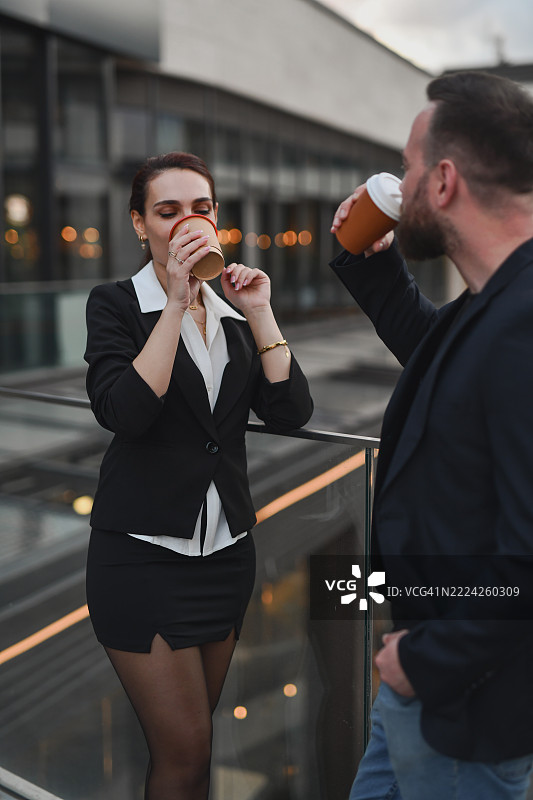 商务专业人士在公司露台上休息时一起喝咖啡图片素材