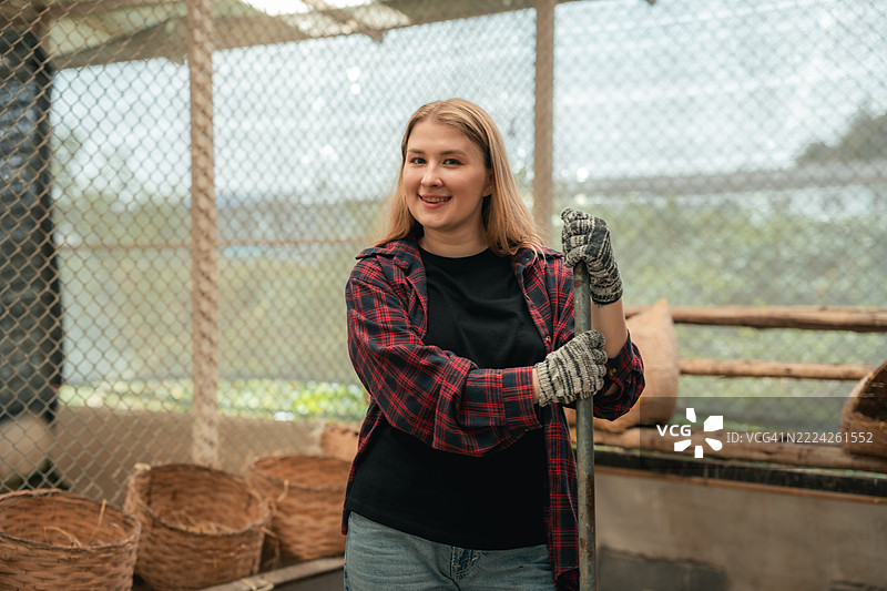 年轻女性在城市农场清理鸡舍图片素材