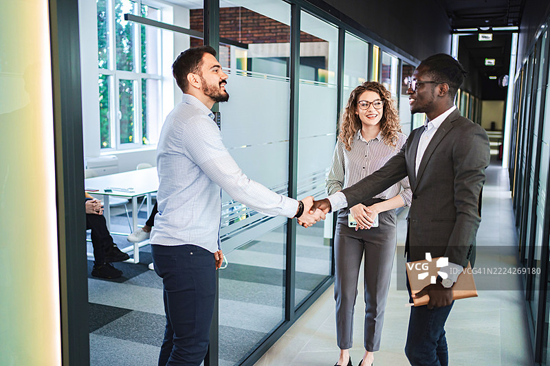 商务人士在办公室走廊握手图片素材