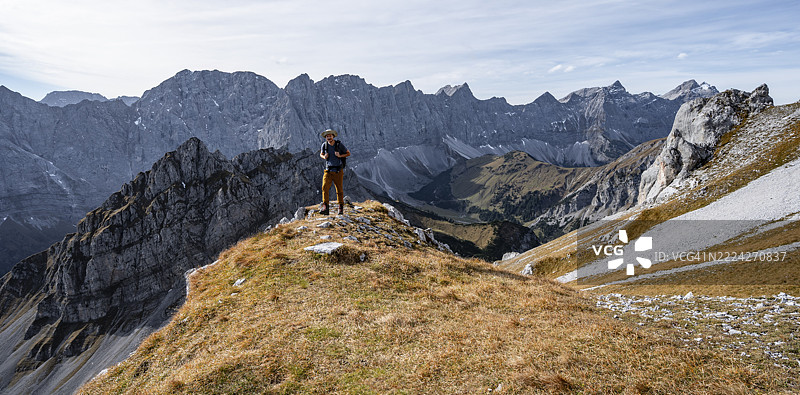 秋季风光下登山者,远眺哈特奥陶山脉-沃姆佩尔山脉的岩石山脊,位于奥地利蒂罗尔州恩格的里斯特尔山谷,卡文德尔山脉,欧洲图片素材