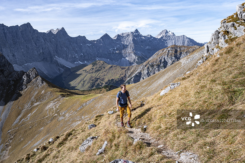 秋季背景下，登山者在加姆斯约赫（Gamsjoch）的徒步小径上，描绘了如画般壮丽的山景，可远眺兴特劳陶尔-沃姆珀山脉（Hinterautal-Vomper chain）的岩石山脊，以及位于恩格（Eng）的里斯特尔（Rißtal），这里是奥地利蒂罗尔州卡文德尔山区的欧洲地貌。图片素材