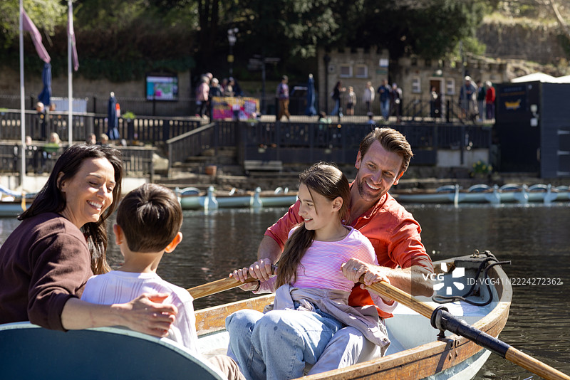 快乐的家庭在阳光明媚的日子里划船图片素材