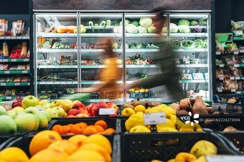 忙碌的顾客在超市推着购物车图片素材