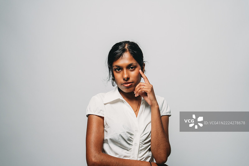 年轻女性触摸脸庞，思考着什么图片素材