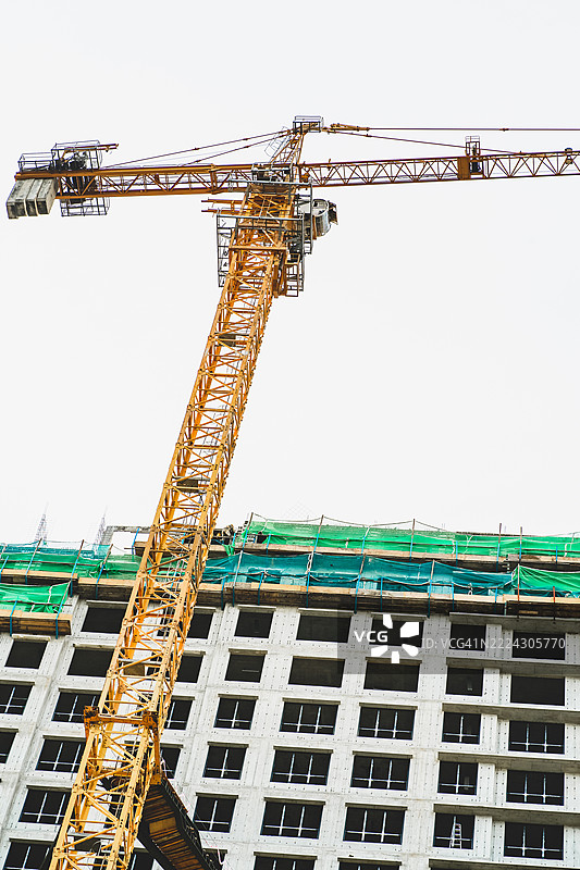 马来西亚正在建设中的公寓楼与施工起重机的低角度视图图片素材