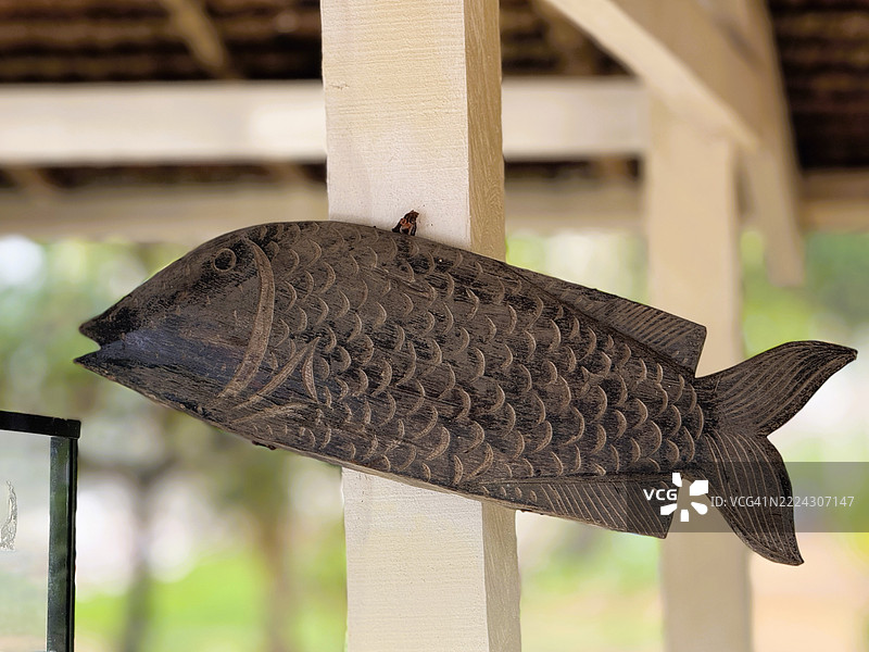 手工雕刻的木鱼雕塑，竖立在柱子上，菲律宾米马罗巴图片素材