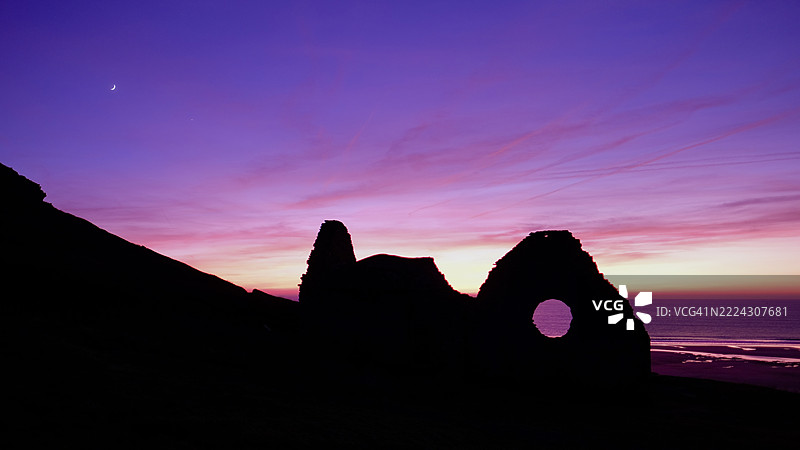日落时分，诺曼底，法国海滩上的岩石剪影与天空相映成趣。图片素材