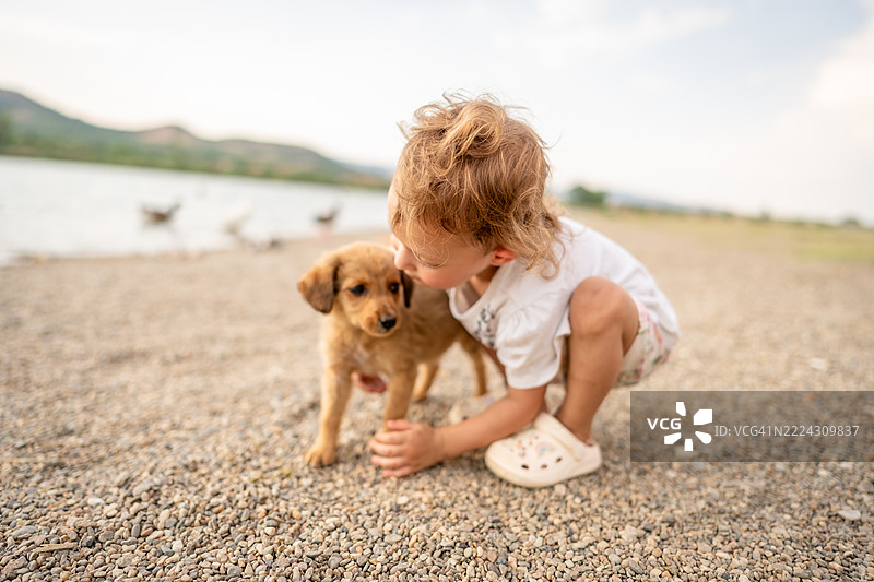 可爱的小宝宝在户外和小狗玩耍图片素材