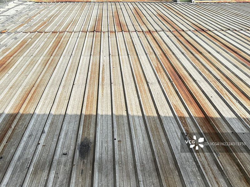 在马来西亚吉隆坡，锈蚀的金属屋顶在正午阳光下显现出风化迹象。图片素材