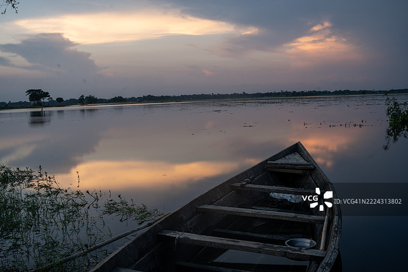 湖面上倒映着宁静日落的木船，洛基贡，孟加拉国图片素材