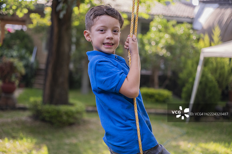 孩子们在秋千上荡秋千，父亲在一旁观看。图片素材