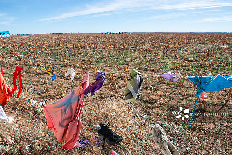 鞋子和其他纪念品挂在卡迪拉克牧场边界的公共围栏上，留给游客的痕迹。图片素材