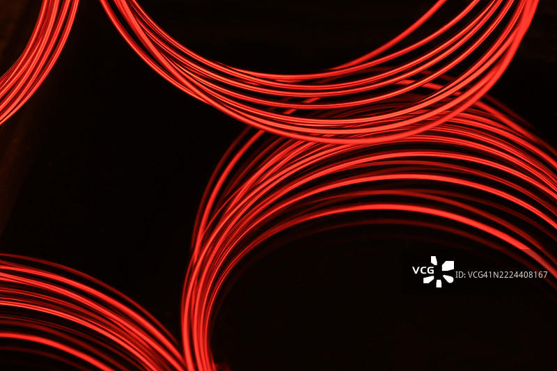 鲜艳红色电线的线圈与黑色背景的反射图片素材