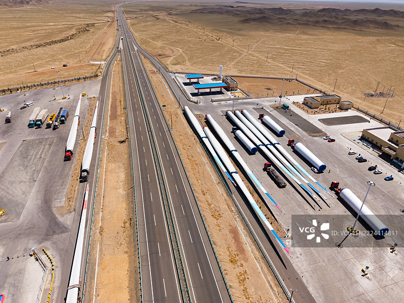 一辆运输风力涡轮机的卡车在高速公路休息区停下来休息。图片素材