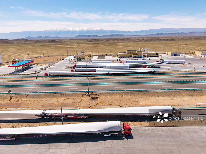 一辆运输风力涡轮机的卡车在高速公路休息区停下来休息。图片素材