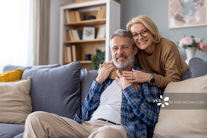 沙发上情侣之间温暖的微笑和共享的爱意图片素材