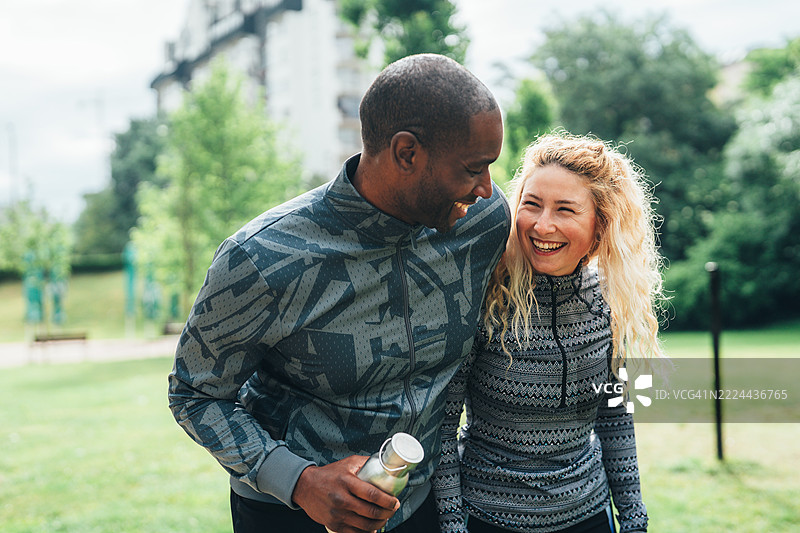 朋友们在城市公园户外锻炼后欢笑交谈图片素材