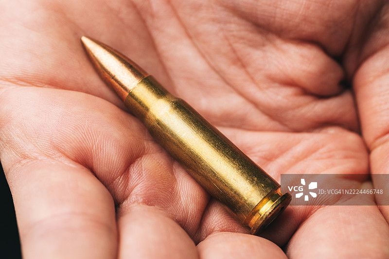 男性手中握着卡拉什尼科夫突击步枪的弹匣图片素材