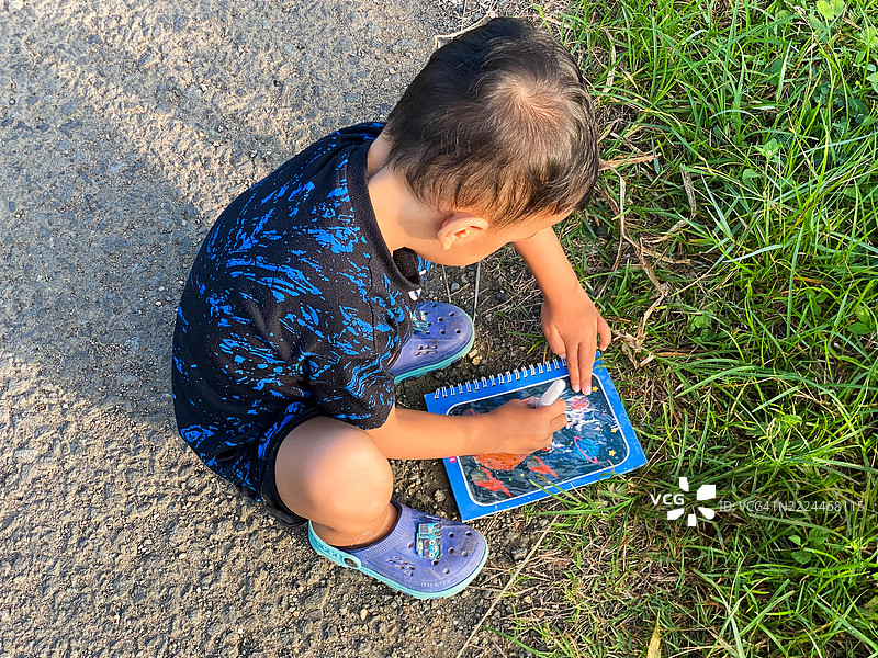 一个幼儿在大自然中绘画图片素材