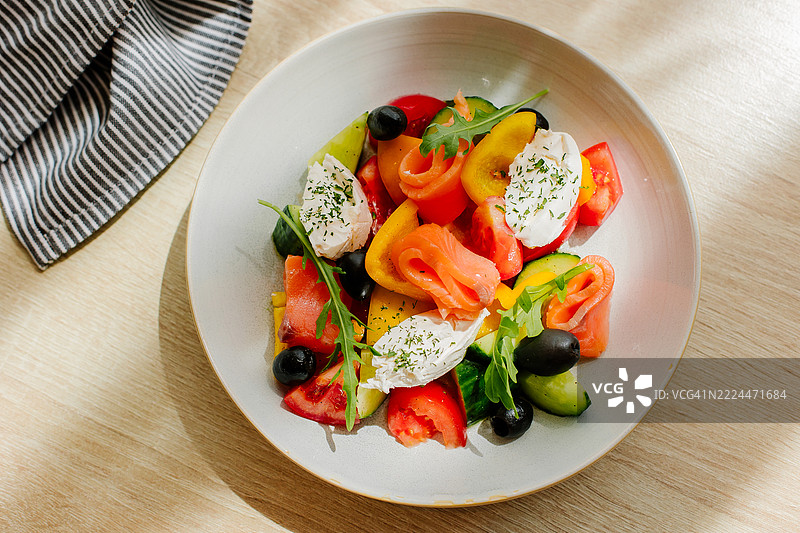 色彩鲜艳的新鲜沙拉菜肴，搭配蔬菜和奶油奶酪，盛放在白色盘子上图片素材