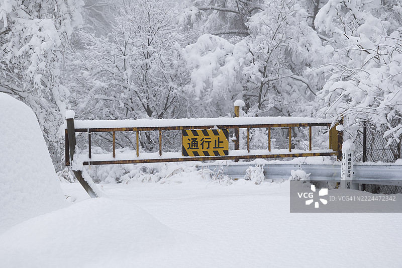 被大雪封堵的森林道路，关闭的门图片素材