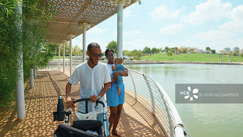 家庭在风景如画的湖边小径上散步图片素材