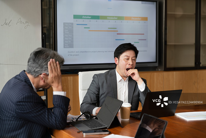 亚洲商人在会议室中感到疲惫。图片素材