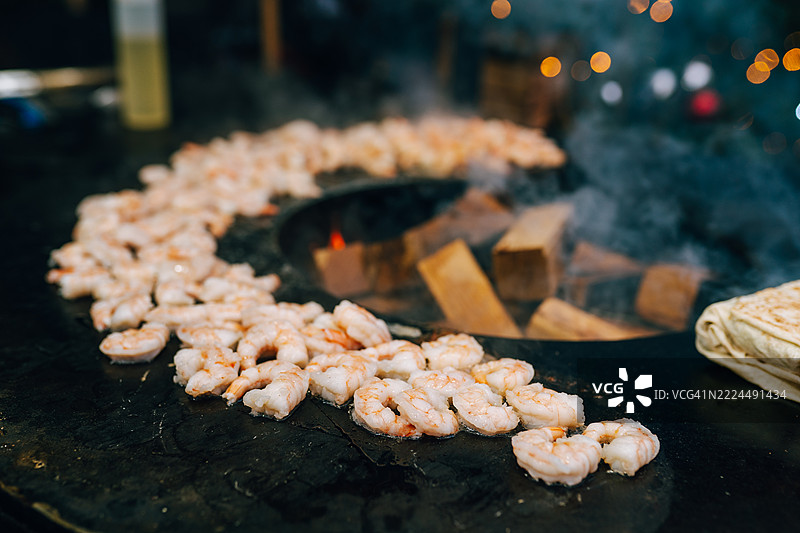 在大圆形热煎锅上烹饪虾仁图片素材