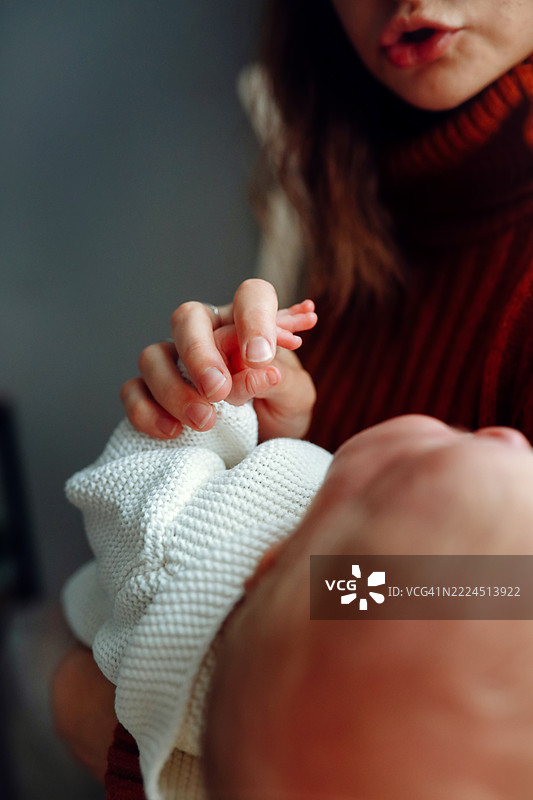 特写：母亲的手温柔地握住新生儿的小手。图片素材