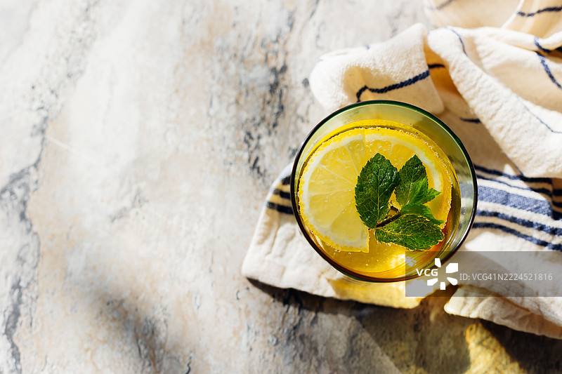 大理石背景上的清新柠檬薄荷饮品。生动展现了夏季清爽饮品，搭配柠檬片和薄荷叶。图片素材
