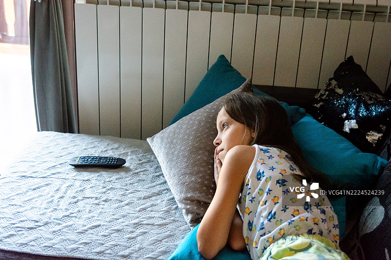 女孩躺在沙发上看电视图片素材