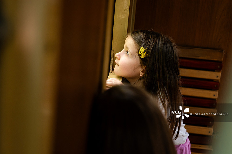 女孩在旅游列车的窗户旁望外。图片素材