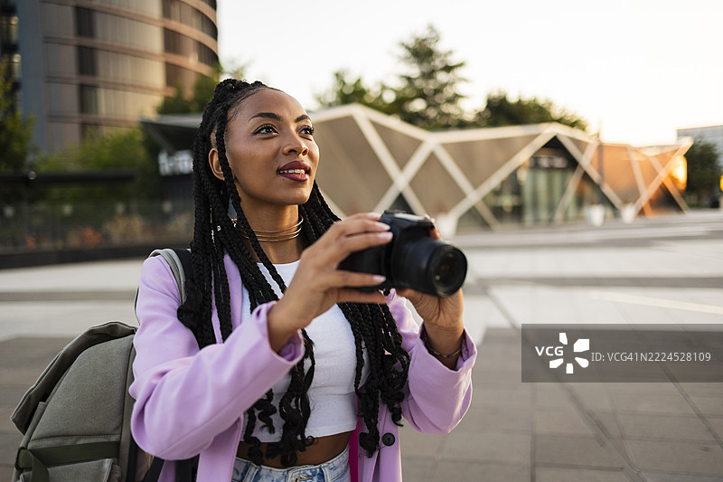 年轻女性用相机探索城市建筑图片素材